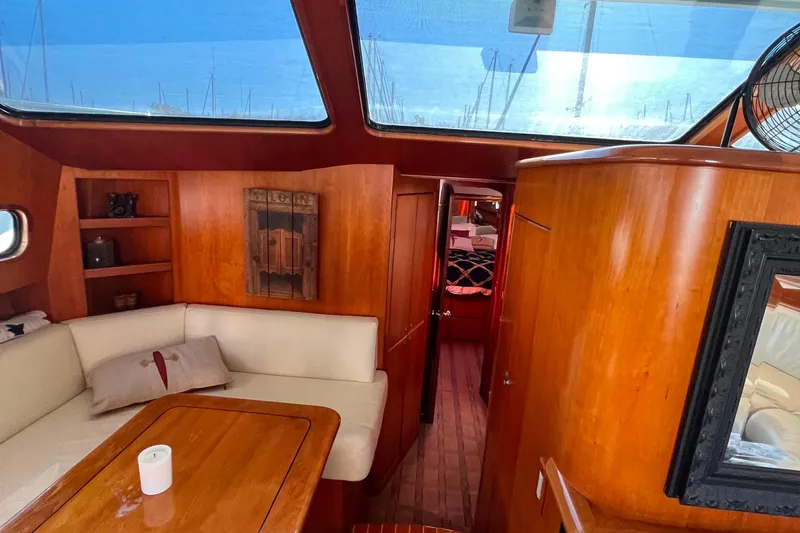 The Donut Hull Yacht Photos Pics Interior of 2002 Mikelson 50 Flybridge yacht with wood paneling and seating area.
