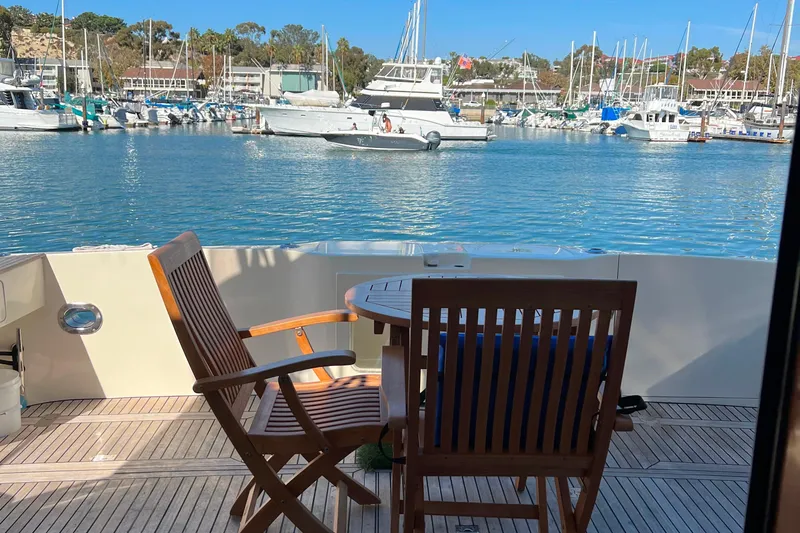 The Donut Hull Yacht Photos Pics 2002 Mikelson 50 Flybridge yacht with wooden deck chairs overlooking marina.