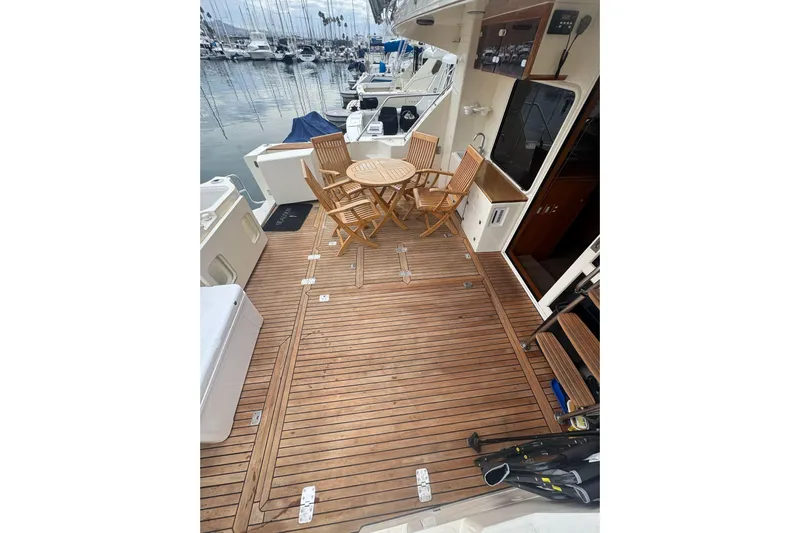 The Donut Hull Yacht Photos Pics 2002 Mikelson 50 Flybridge yacht deck with wooden flooring and outdoor seating.