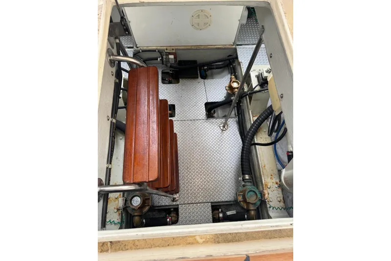 The Donut Hull Yacht Photos Pics Engine compartment of 2002 Mikelson 50 Flybridge with wooden steps and metal flooring.