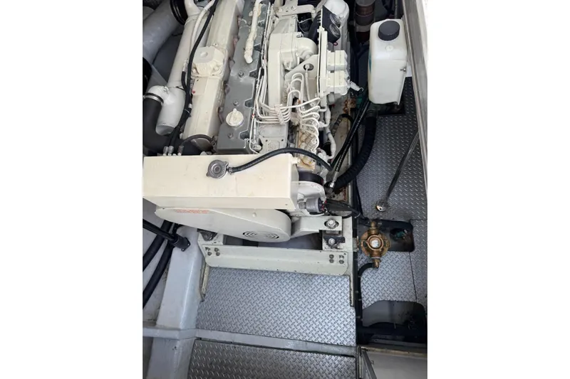 The Donut Hull Yacht Photos Pics Engine compartment of 2002 Mikelson 50 Flybridge with visible components and metallic flooring.