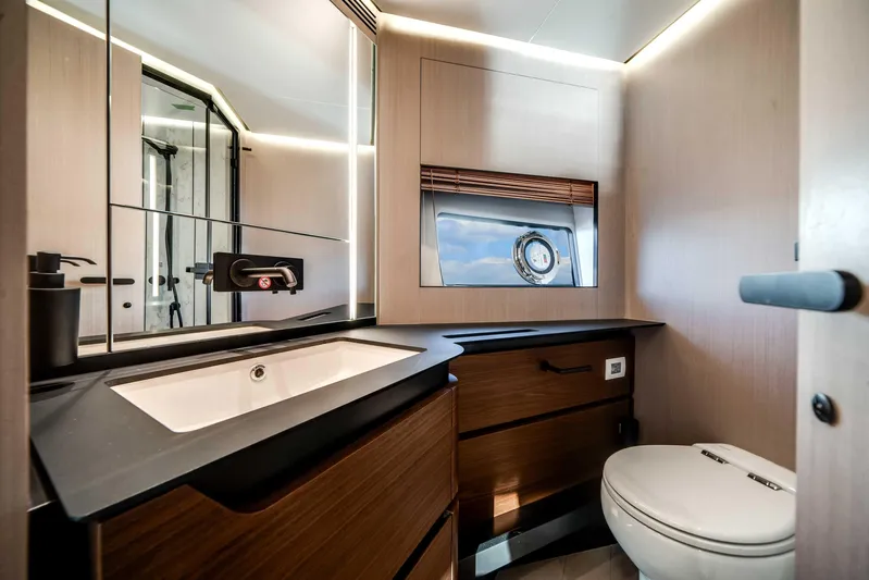  Yacht Photos Pics Luxurious bathroom interior of 2025 Azimut S8 yacht with modern fixtures and porthole view.