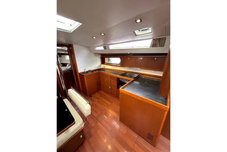  Yacht Photos Pics Interior of 2015 Beneteau Oceanis 48 yacht with modern kitchen and wood finish.