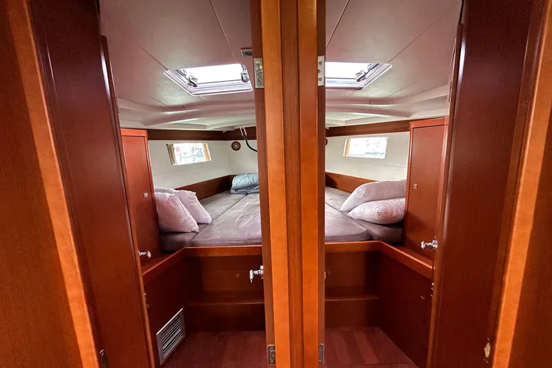  Yacht Photos Pics 2015 Beneteau Oceanis 48 cabin interior with cozy bedding and wooden finish.