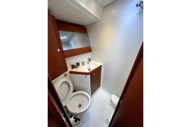  Yacht Photos Pics Beneteau Oceanis 48 (2015) yacht bathroom with wooden cabinetry and modern fixtures.