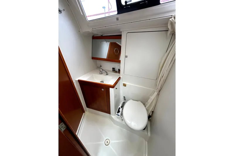  Yacht Photos Pics Beneteau Oceanis 48 (2015) yacht bathroom with sink, mirror, and toilet.