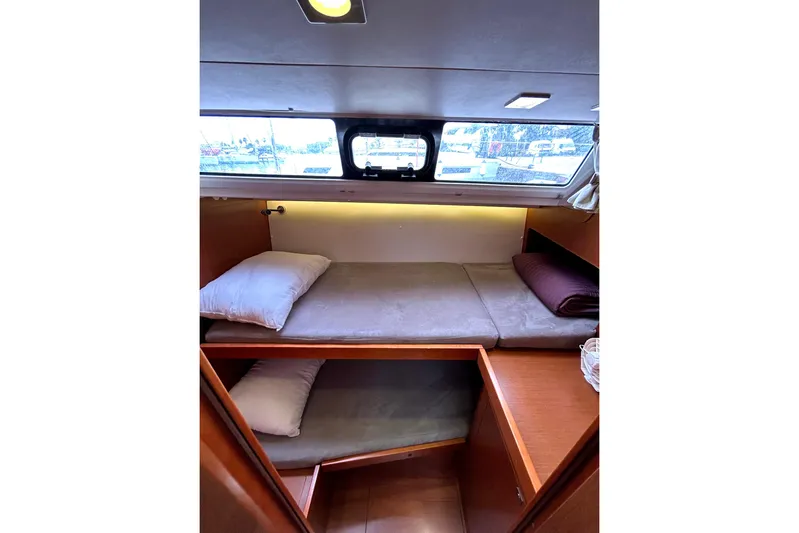  Yacht Photos Pics 2015 Beneteau Oceanis 48 cabin interior with cozy twin beds and window view.