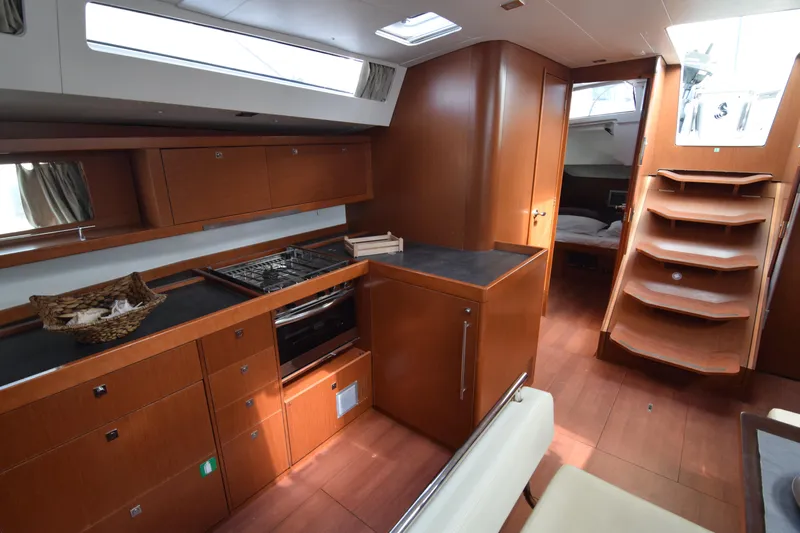  Yacht Photos Pics Interior of 2015 Beneteau Oceanis 48 yacht, featuring modern kitchen and wooden cabinetry.
