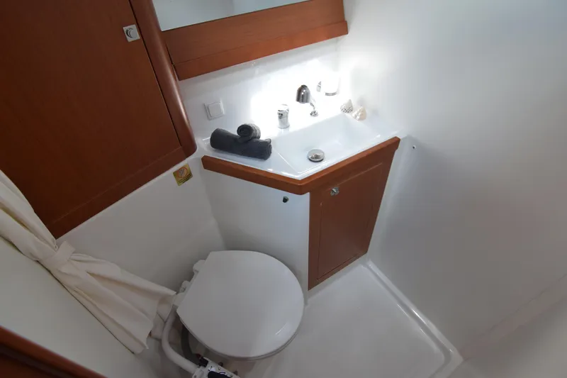  Yacht Photos Pics 2015 Beneteau Oceanis 48 bathroom with sink, toilet, and wooden cabinetry.