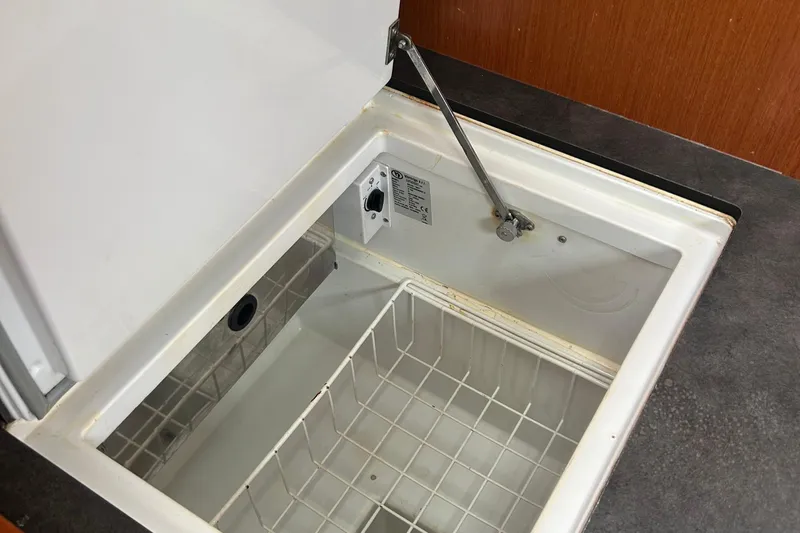  Yacht Photos Pics Open storage compartment on 2015 Beneteau Oceanis 48 yacht, featuring a wire basket.