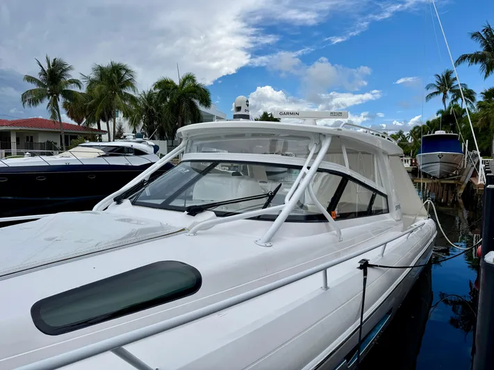 Yacht Photos Pics 2023 Intrepid 438 Evolution yacht docked with palm trees and blue sky background.