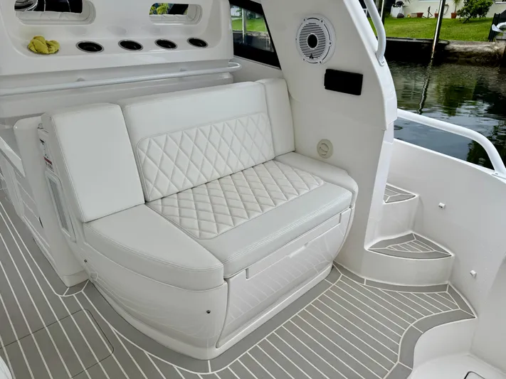  Yacht Photos Pics 2023 Intrepid 438 Evolution boat interior with white cushioned seating and sleek design.