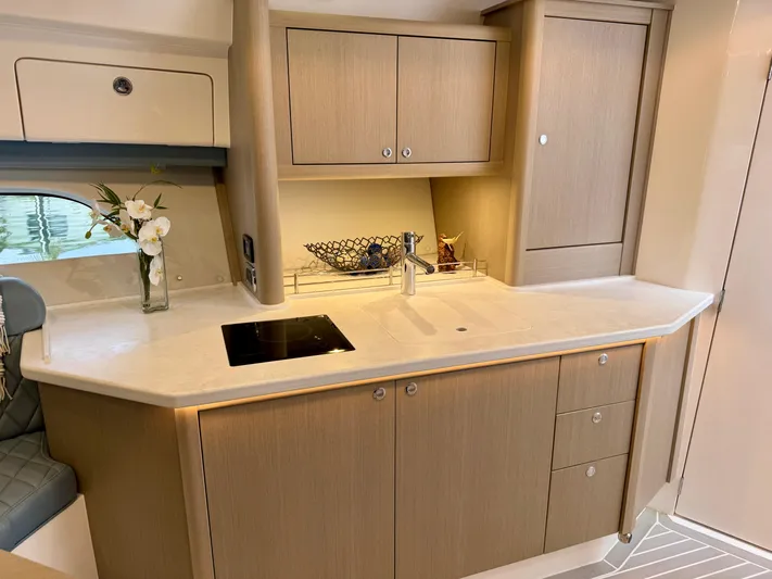  Yacht Photos Pics Luxurious 2023 Intrepid 438 Evolution yacht kitchen with modern cabinetry and sleek countertop.