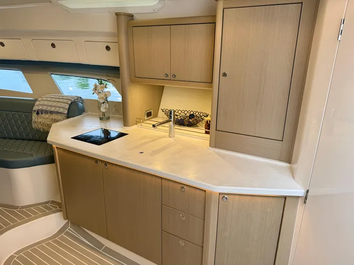  Yacht Photos Pics Luxurious 2023 Intrepid 438 Evolution yacht interior with modern kitchen and seating area.