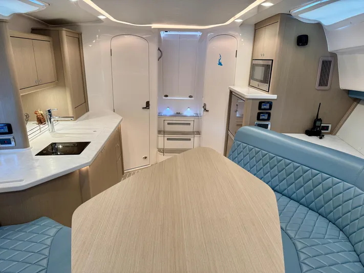  Yacht Photos Pics Luxurious interior of 2023 Intrepid 438 Evolution yacht with modern kitchen and seating area.