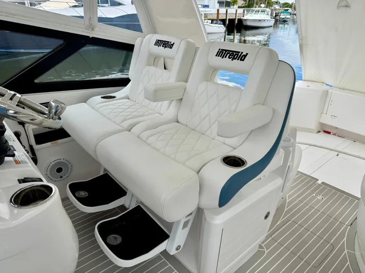  Yacht Photos Pics Luxury seating on 2023 Intrepid 438 Evolution yacht, featuring white quilted upholstery.