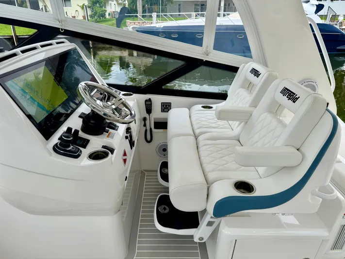  Yacht Photos Pics 2023 Intrepid 438 Evolution helm with luxurious seating and advanced navigation controls.