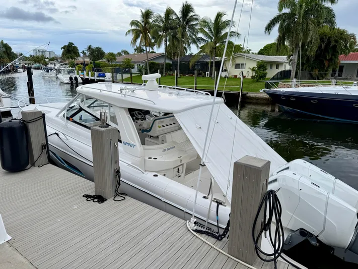  Yacht Photos Pics 2023 Intrepid 438 Evolution yacht docked by a waterfront with palm trees.