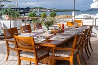 Elegant dining setup on 1986 Motor Yacht 38m Nicolini, overlooking serene marina views.