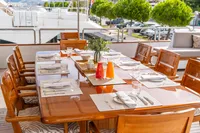 Elegant dining setup on 1986 Motor Yacht 38m Nicolini, featuring wooden table and chairs.