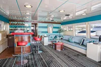 Luxurious interior of 1986 Motor Yacht 38m Nicolini with bar, seating, and striped carpet.