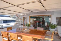 Luxurious 1986 Motor Yacht 38m Nicolini with elegant outdoor dining and spiral staircase.