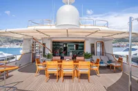 Luxurious 1986 Motor Yacht 38m Nicolini with elegant outdoor dining area and scenic views.