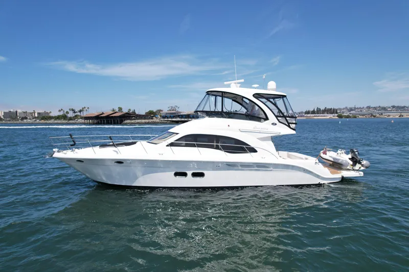 One Shot Yacht Photos Pics 2007 Sea Ray 52 Sedan Bridge yacht cruising on a sunny day near the coastline.