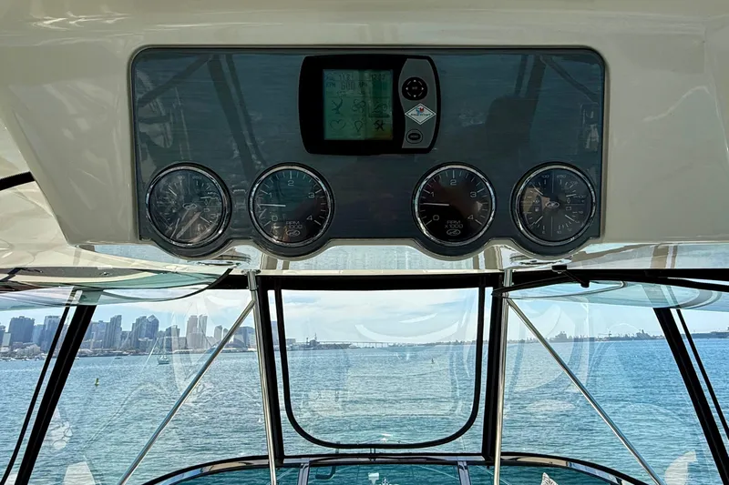 One Shot Yacht Photos Pics 2007 Sea Ray 52 Sedan Bridge helm with gauges, overlooking city skyline and ocean.