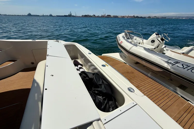 One Shot Yacht Photos Pics 2007 Sea Ray 52 Sedan Bridge yacht with tender, docked on calm waters.