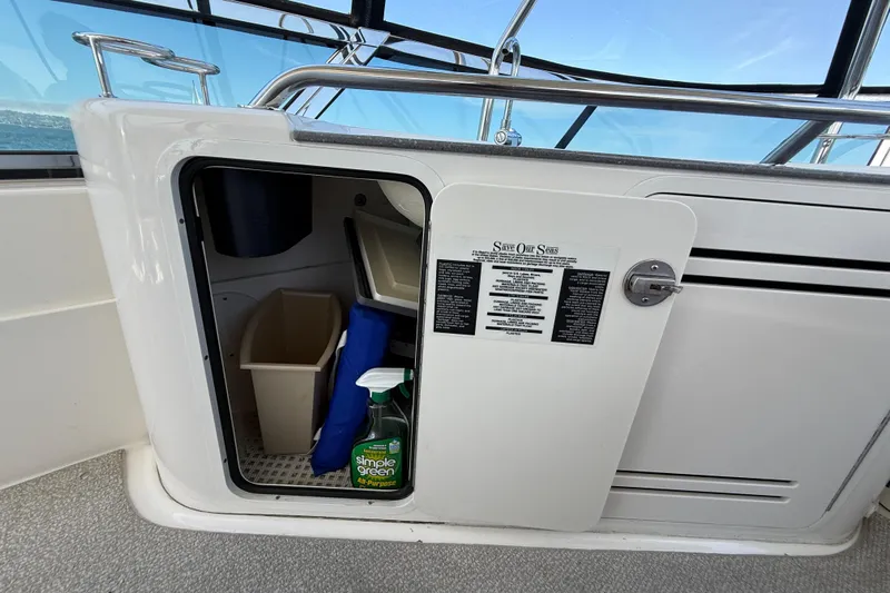One Shot Yacht Photos Pics 2007 Sea Ray 52 Sedan Bridge storage compartment with cleaning supplies and waste bin.