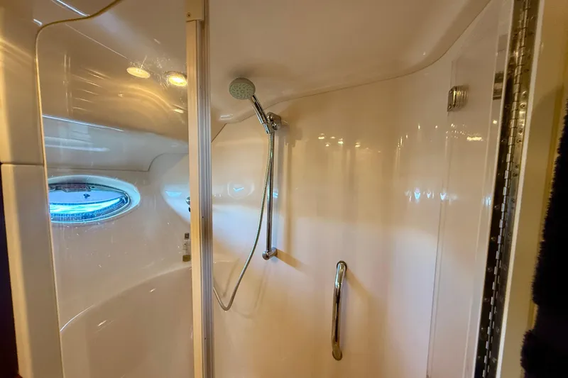 One Shot Yacht Photos Pics Shower area in 2007 Sea Ray 52 Sedan Bridge yacht with porthole and handheld showerhead.