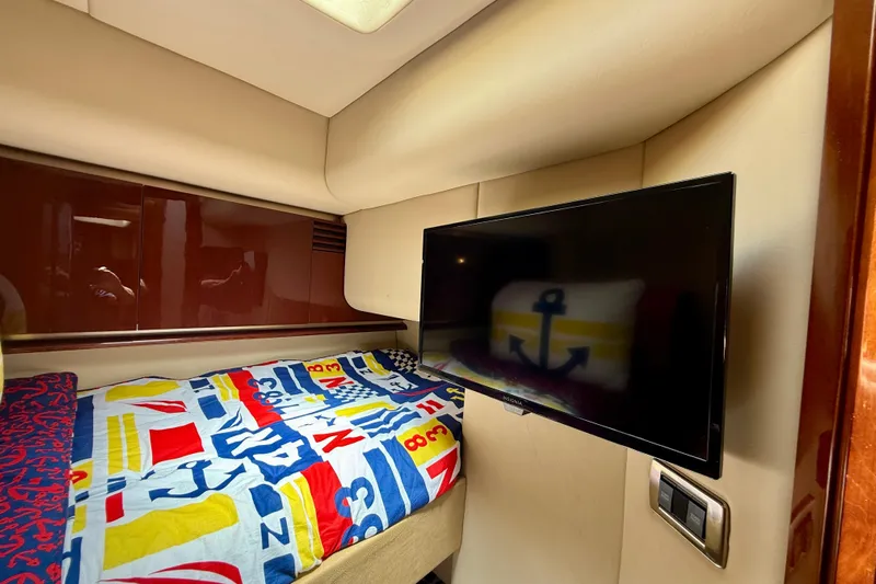 One Shot Yacht Photos Pics 2007 Sea Ray 52 Sedan Bridge cabin with colorful bedding and wall-mounted TV.