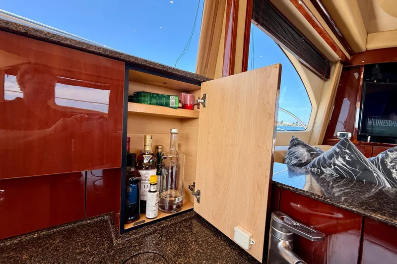 One Shot Yacht Photos Pics 2007 Sea Ray 52 Sedan Bridge interior with open cabinet displaying liquor bottles.
