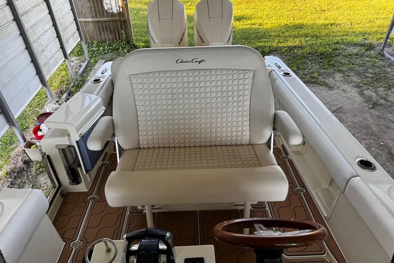  Yacht Photos Pics 2019 Chris-Craft Catalina 26 boat interior with white seating and wooden steering wheel.