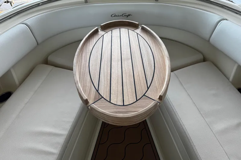  Yacht Photos Pics 2019 Chris-Craft Catalina 26 interior with wooden table and cushioned seating.