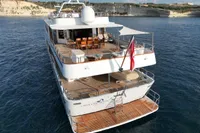 38m Nicolini Motor Yacht, 1986, cruising in serene blue waters near rocky coastline.