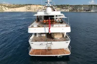 38m Nicolini motor yacht, 1986, cruising on calm waters near rocky coastline.