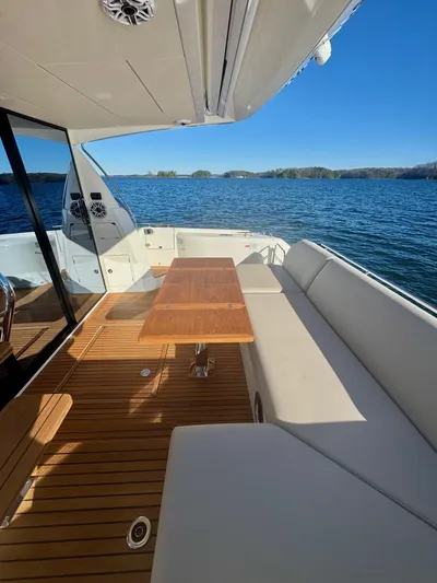 Sandybay Yacht Photos Pics Prestige 520 Fly 2022 yacht deck with seating and table, overlooking serene water.