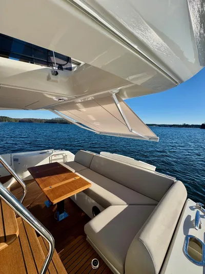 Sandybay Yacht Photos Pics Prestige 520 Fly 2022 yacht deck with seating and table, overlooking serene water.
