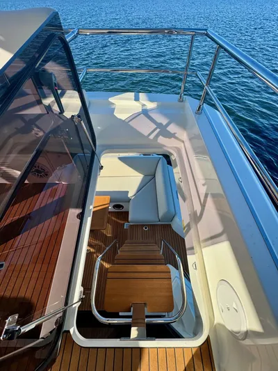 Sandybay Yacht Photos Pics Prestige 520 Fly 2022 yacht flybridge with wooden deck and seating, overlooking the ocean.