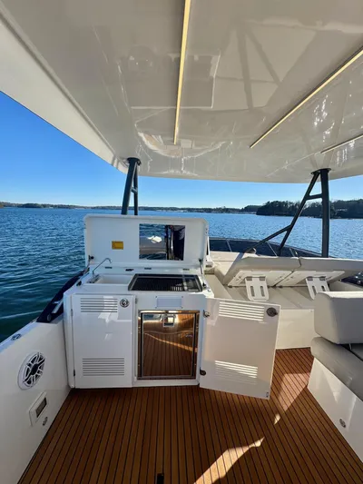 Sandybay Yacht Photos Pics Prestige 520 Fly 2022 yacht deck with outdoor kitchen and seating, overlooking serene waters.