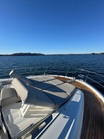 Sandybay Yacht Photos Pics Prestige 520 Fly 2022 yacht with sun loungers on deck, overlooking serene waters.
