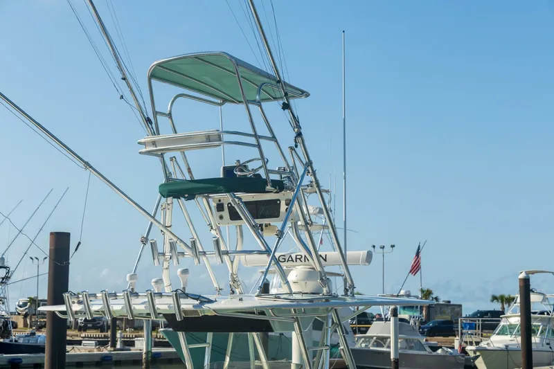 4 Getaway Yacht Photos Pics 2005 Venture 39 Open boat with tower and fishing rods at marina.