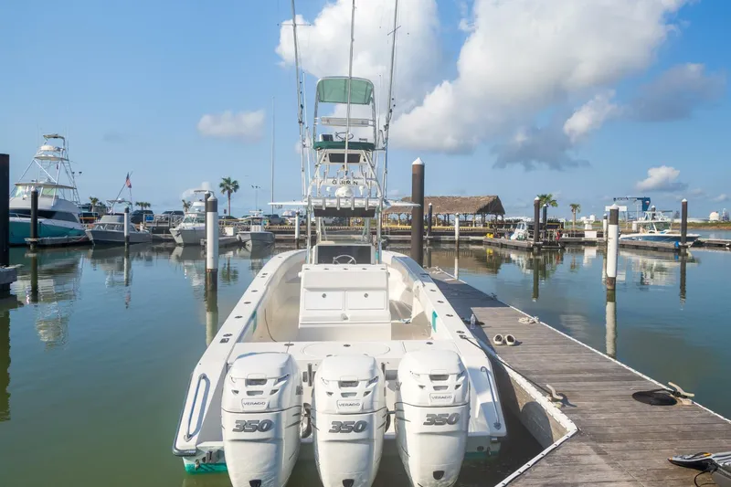 4 Getaway Yacht Photos Pics 2005 Venture 39 Open boat docked with triple engines in a marina.