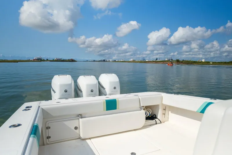 4 Getaway Yacht Photos Pics 2005 Venture 39 Open boat with triple engines on calm water.