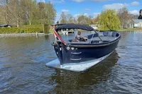 2018 Davy & Orsted 10.50 Open boat cruising on a calm river under a clear blue sky.