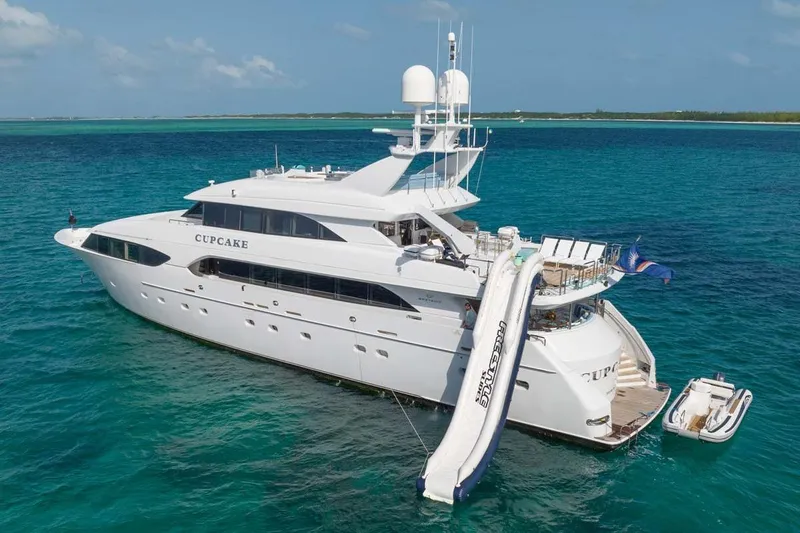 Cupcake Yacht Photos Pics Luxury 2001 Westship Skylounge yacht with waterslide, anchored in clear blue ocean.