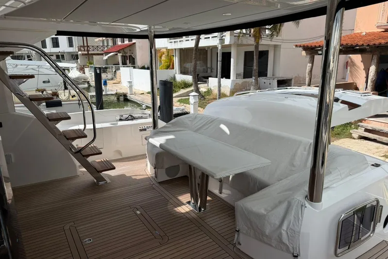 Atkun Yacht Photos Pics 2021 Sunseeker Manhattan 68 yacht deck with covered seating and wooden stairs.