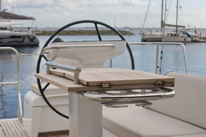  Yacht Photos Pics Cockpit of 2022 Beneteau Oceanis Yacht 54 with steering wheel and foldable table.